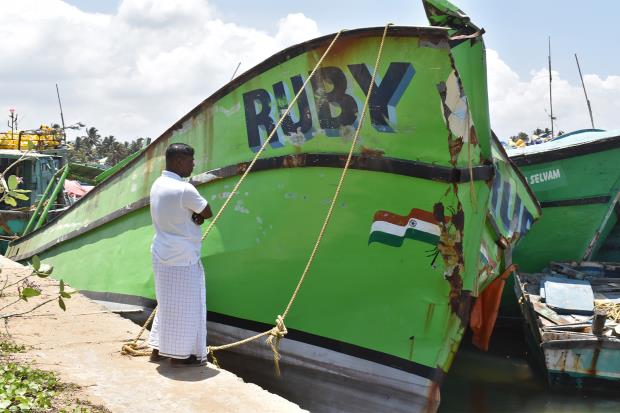 Anthoni Dhasan at the Thengapattanam harbour with his wrecked boat Ruby. 