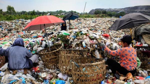 People collect plastic waste to sell to a recycling centre at a landfill in Medan, North Sumatra